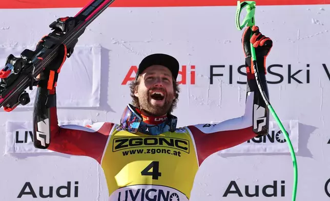 Austria's Marco Schwarz celebrates on the podium after winning an alpine ski, men's World Cup Super G, in Livigno, Italy, Saturday, Dec. 27, 2025. (AP Photo/Marco Trovati)