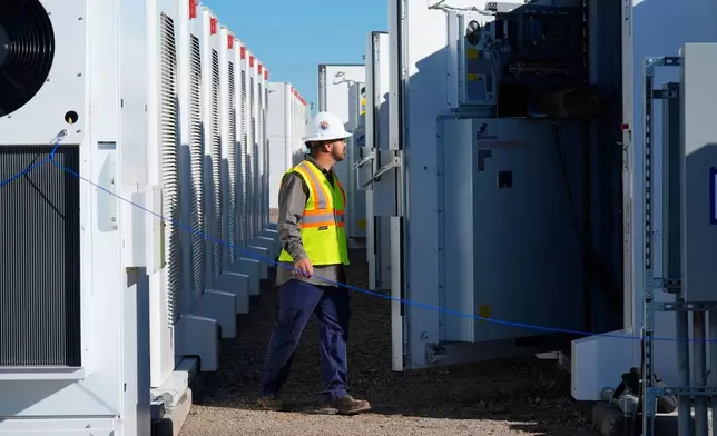 FILE - A worker does checks on battery storage pods at Orsted's Eleven Mile Solar Center lithium-ion battery storage energy facility Feb. 29, 2024, in Coolidge, Ariz. (AP Photo/Ross D. Franklin, File)
