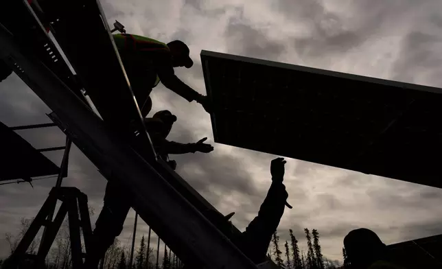 FILE - Workers install panels at a solar project May 21, 2025, in Galena, Alaska. (AP Photo/John Locher, File)