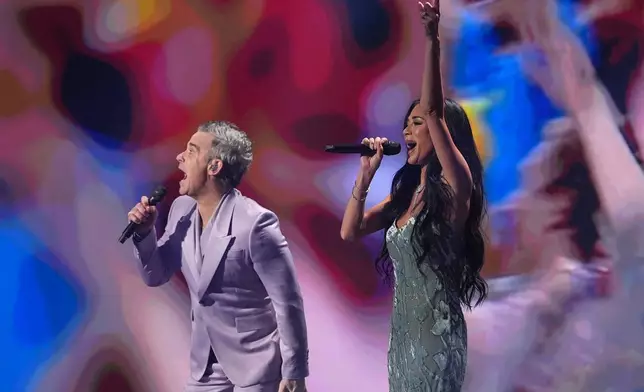 Singer Robbie Williams and singer and actor Nicole Scherzinger perform during the draw for the 2026 soccer World Cup at the Kennedy Center in Washington, Friday, Dec. 5, 2025. (AP Photo/Jacquelyn Martin)