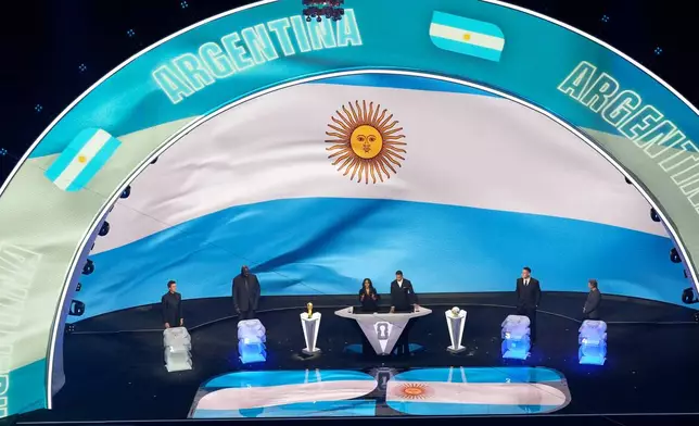 From left; former NFL player Tom Brady, former NBA player Shaquille O'Neal, broadcaster Samantha Johnson, former England soccer captain Rio Ferdinand, New York Yankees' Aaron Judge and former NHL player Wayne Gretzky participate in the draw for the 2026 soccer World Cup at the Kennedy Center in Washington, Friday, Dec. 5, 2025. (AP Photo/Alex Brandon)