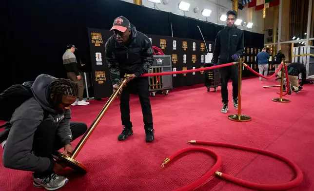 Workers prepare the red carpet area prior to the final draw for the 2026 soccer World Cup at the Kennedy Center in Washington, Thursday, Dec. 4, 2025. (AP Photo/Chris Carlson)