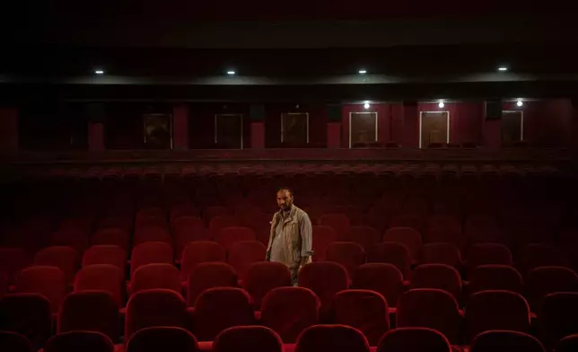 FILE - Gul Mohammed, who works as an usher in the Ariana Cinema, poses for a photograph in Kabul, Afghanistan, Nov. 4, 2021, before the cinema was demolished in December 2025 by Taliban authorities to make way for a new shopping center. (AP Photo/Bram Janssen, File)