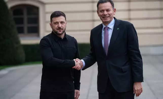 Ukraine's President Volodymyr Zelenskyy, left, shakes hands with Portuguese Prime Minister Luís Montenegro in Kyiv, Ukraine, Saturday, Dec. 20, 2025. (AP Photo/Danylo Antoniuk)