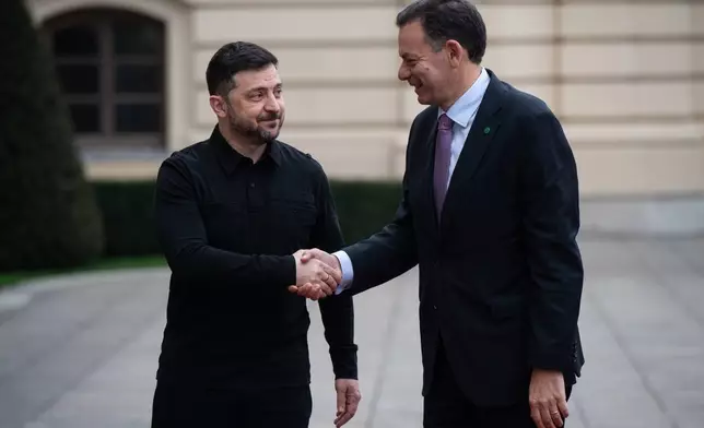 Ukraine's President Volodymyr Zelenskyy, left, shakes hands with Portuguese Prime Minister Luís Montenegro in Kyiv, Ukraine, Saturday, Dec. 20, 2025. (AP Photo/Danylo Antoniuk)
