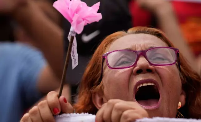 A demonstrator shouts "No amnesty" in Portuguese during a protest against a bill in that looks to reduce former President Jair Bolsonaro's prison time, in Brasilia, Brazil, Sunday, Dec. 14, 2025. (AP Photo/Eraldo Peres)