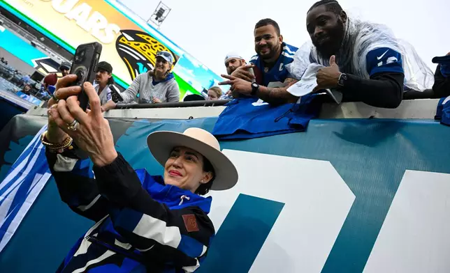 Indianapolis Colts owner and CEO Carlie Irsay-Gordon poses for a photo with fans before an NFL football game between the Indianapolis Colts and the Jacksonville Jaguars, Sunday, Dec. 7, 2025, in Jacksonville, Fla. (AP Photo/Phelan M. Ebenhack)