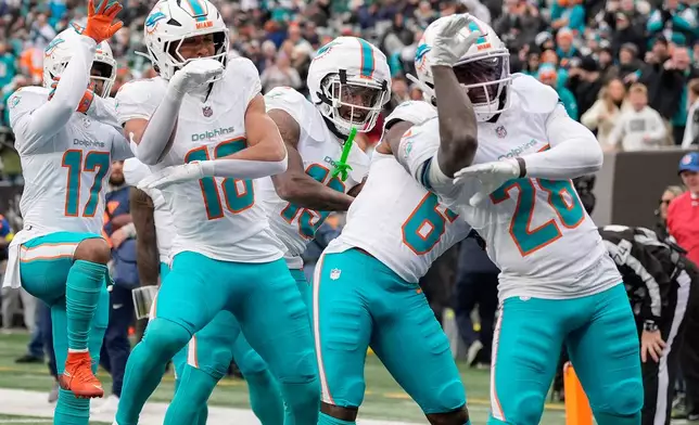 The Miami Dolphins celebrate after a touchdown against the New York Jets during the first quarter of an NFL football game, Sunday, Dec. 7, 2025, in East Rutherford, N.J. (AP Photo/Yuki Iwamura)