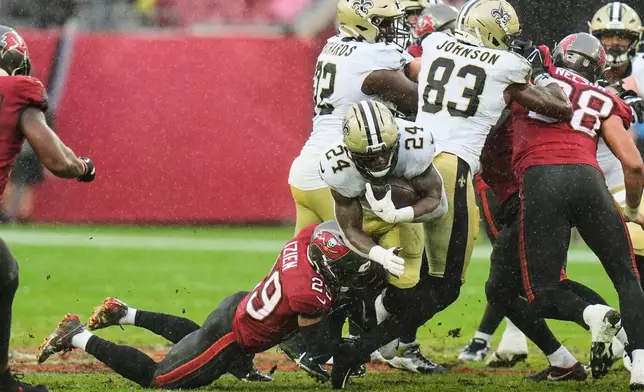 New Orleans Saints running back Devin Neal (24) carries against Tampa Bay Buccaneers safety Christian Izien (29) in the second half of an NFL football game, Sunday, Dec. 7, 2025, in Tampa, Fla. (AP Photo/Chris O'Meara)