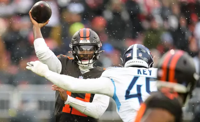 Cleveland Browns quarterback Shedeur Sanders (12) throws a pass under pressure from Tennessee Titans linebacker Arden Key, right, in the first half of an NFL football game in Cleveland, Sunday, Dec. 7, 2025. (AP Photo/Sue Ogrocki)