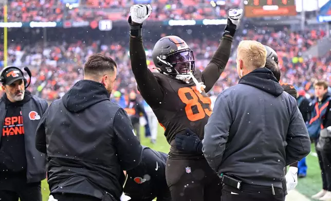 Cleveland Browns tight end David Njoku (85) celebrates his touchdown catch as team staff check on him for a potential injury in the first half of an NFL football game against the Tennessee Titans in Cleveland, Sunday, Dec. 7, 2025. (AP Photo/David Richard)