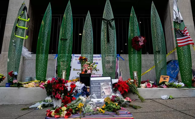 A makeshift memorial for U.S. Army Spc. Sarah Beckstrom and U.S. Air Force Staff Sgt. Andrew Wolfe is seen outside of Farragut West Station, near the site where the two National Guard members were shot, Monday, Dec. 1, 2025, in Washington. (AP Photo/Julia Demaree Nikhinson)