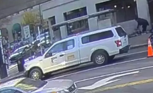 This image contained in a court filing by the Department of Justice on Tuesday, Dec. 2, 2025 shows the the defendant, Rahmanullah Lakanwal, top right, bending down next to Specialist Sarah Beckstrom and Staff Sgt. Andrew Wolfe after shooting them, according to police. (Department of Justice via AP)