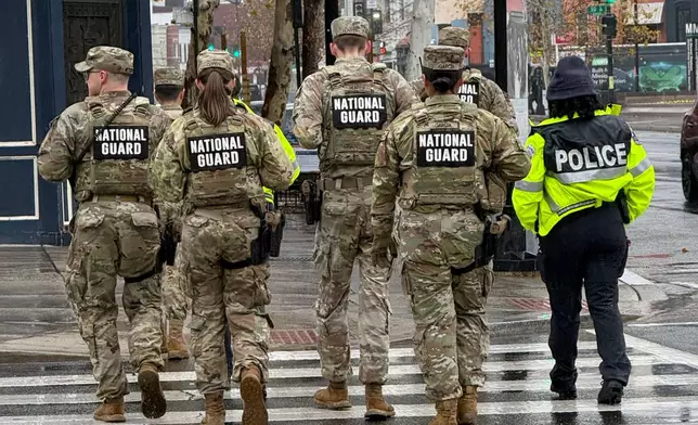 Members of the National Guard and an officer from the Washington Metropolitan Police Department on foot patrols in the U Street neighborhood of Washington, Sunday, Nov., 30, 2025. (AP Photo/Pablo Martinez Monsivais)