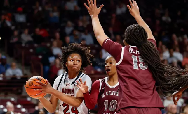South Carolina guard Ayla McDowell (24) looks to shoot against North Carolina Central guard Shakiria Foster (10) and forward Dianna Blake during the first half of an NCAA college basketball game in Columbia, S.C., Sunday, Dec. 7, 2025. (AP Photo/Nell Redmond)
