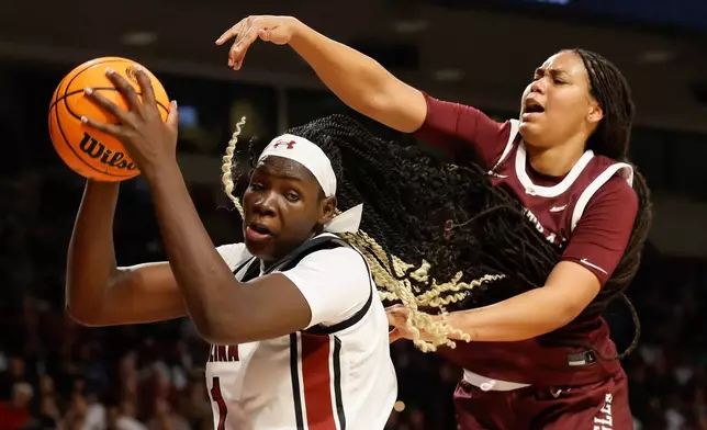 South Carolina center Madina Okot, left, pulls down an offensive rebound against North Carolina Central forward Dianna Blake during the first half of an NCAA college basketball game in Columbia, S.C., Sunday, Dec. 7, 2025. (AP Photo/Nell Redmond)