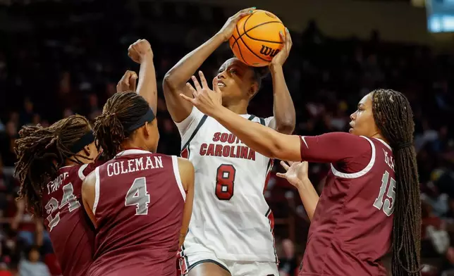 South Carolina forward Joyce Edwards (8) drives to the basket against North Carolina Central forward Aniya Finger (24), guard Tierney Coleman (4) and forward Dianna Blake (15) during the first half of an NCAA college basketball game in Columbia, S.C., Sunday, Dec. 7, 2025. (AP Photo/Nell Redmond)