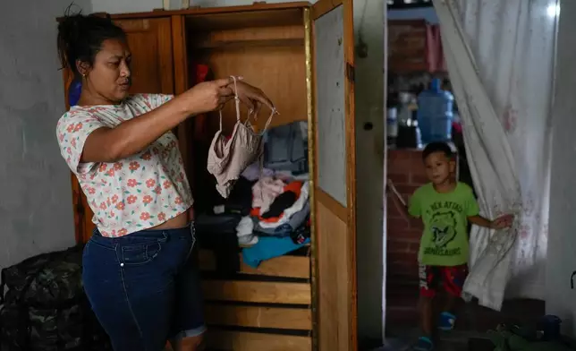 Mariela Gómez, a Venezuelan migrant who gave up her journey with her children to the United States following the immigration crackdown under President Donald Trump, chooses what to wear for a family Christmas dinner in Maracay, Venezuela, Friday, Dec. 24, 2025. (AP Photo/Matias Delacroix)