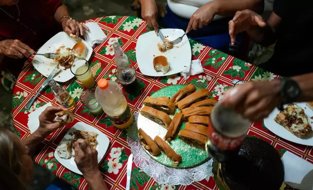 Christmas dinner is served at the home of Abraham Castro's parents in Maracay, Venezuela, early Thursday, Dec. 25, 2025. Castro and his partner Mariela Gómez, a Venezuelan migrant couple who abandoned their journey to the United States following thPresident Donald Trump's immigration crackdown, are spending the holiday there after returning home. (AP Photo/Matias Delacroix)