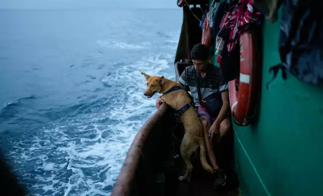 FILE - Venezuelan Abraham Castro rides a cargo vessel with other Venezuelan migrants through the Gulf of Panama as he, his partner and her two sons travel south after giving up on reaching the United States, Sept. 17, 2025. (AP Photo/Matias Delacroix, File)