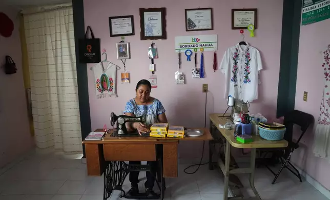 Virginia Veronica Arce Arce, a designer of Nahua folk art embroidery worn by Mexican President Claudia Sheinbaum, works in her workshop at home in the municipality of San Isidro Buen Suceso, Tlaxcala, Mexico, Friday, Dec. 12, 2025. (AP Photo/Marco Ugarte)