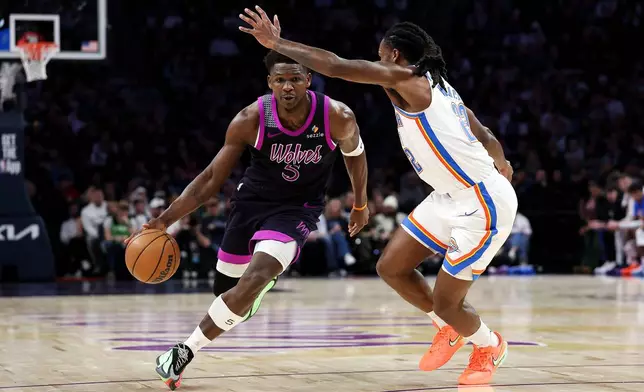 Minnesota Timberwolves guard Anthony Edwards, left, works around Oklahoma City Thunder guard Cason Wallace, right, during the first half of an NBA basketball game Friday, Dec. 19, 2025, in Minneapolis. (AP Photo/Matt Krohn)