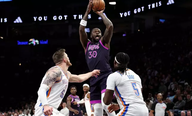 Minnesota Timberwolves forward Julius Randle (30) shoots as Oklahoma City Thunder center Isaiah Hartenstein, left, and guard Luguentz Dort (5) defend during the first half of an NBA basketball game Friday, Dec. 19, 2025, in Minneapolis. (AP Photo/Matt Krohn)