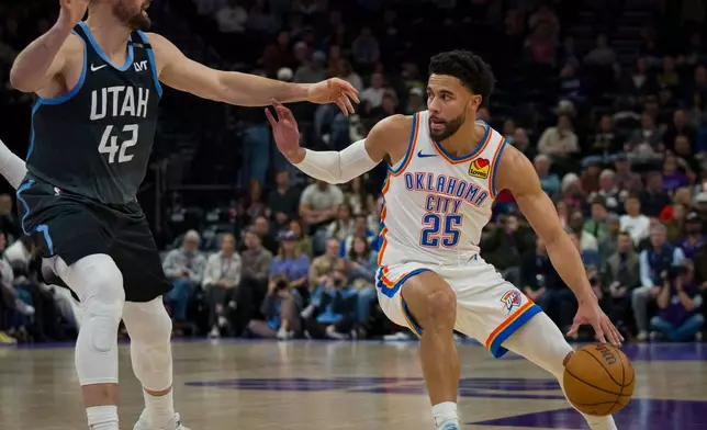 Oklahoma City Thunder guard Ajay Mitchell (25) dribbles as Utah Jazz forward/center Kevin Love (42) defends during the first half of an NBA basketball game Sunday, Dec. 7, 2025, in Salt Lake City. (AP Photo/Bethany Baker)
