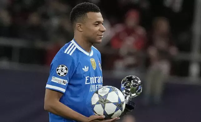 Real Madrid's Kylian Mbappe poses with the trophy after scoring four goal during the Champions League opening phase soccer match between Olympiacos and Real Madrid, in in Piraeus port, near Athens, Greece, Wednesday, Nov. 26, 2025. (AP Photo/Petros Giannakouris)