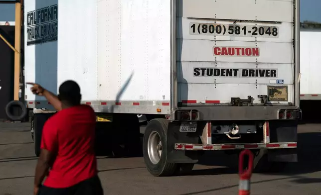 FILE - A student driver helps his classmate steer the wheel into the right direction as they practice driving in reverse in Calif., Nov. 17, 2021. (AP Photo/Jae C. Hong, File)