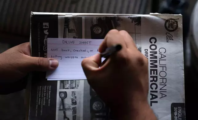 FILE - A student truck driver makes flash cards for his commercial driver's license exam while taking a class in Calif., Nov. 15, 2021. (AP Photo/Jae C. Hong, File)