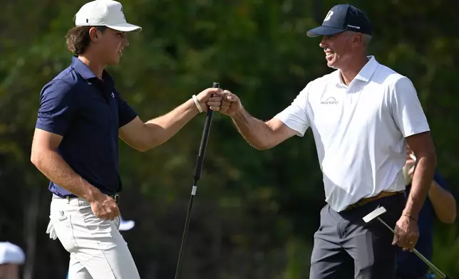 Matt Kuchar, right, gets a fist bump from his son Cameron Kuchar after sinking an eagle putt on the third green during the final round of the PNC Championship golf tournament, Sunday, Dec. 21, 2025, in Orlando, Fla. (AP Photo/Phelan M. Ebenhack)