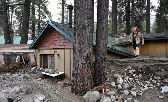 Davey Schneider walks on the roof of his storm-damaged home on Thursday, Dec. 25, 2025, in Wrightwood, Calif. (AP Photo/William Liang)