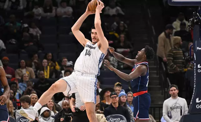 Memphis Grizzlies center Zach Edey (14) grabs a high pass as Los Angeles Clippers guard Cam Christie defends during the first half of an NBA basketball game, Friday, Dec. 5, 2025, in Memphis, Tenn. (AP Photo/John Amis)