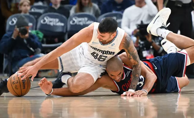 Memphis Grizzlies guard John Konchar (46) and Los Angeles Clippers' Nicolas Batum (33) vie for a loose ball during the first half of an NBA basketball game Friday, Dec. 5, 2025, in Memphis, Tenn. (AP Photo/John Amis)