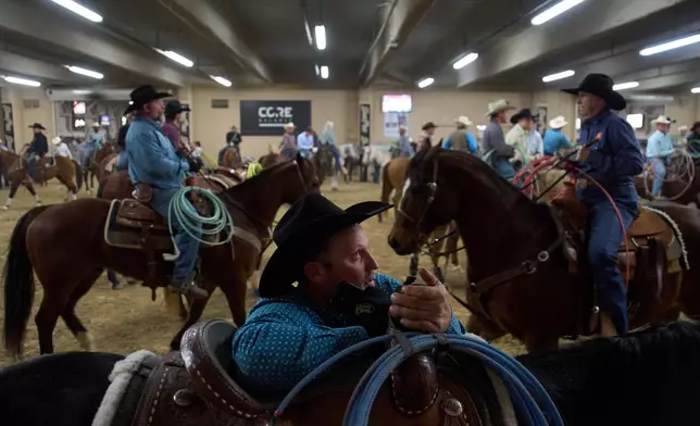 Contestants wait to compete during the World Series of Team Roping at the South Point hotel-casino in Las Vegas Tuesday, Dec. 9, 2025, in Las Vegas. (AP Photo/John Locher)