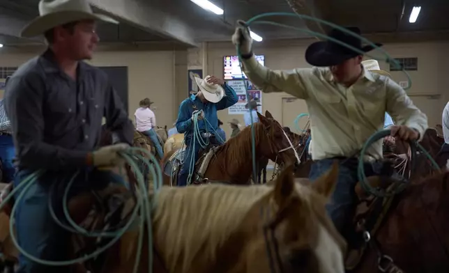Contestants wait to compete during the World Series of Team Roping at the South Point hotel-casino in Las Vegas Tuesday, Dec. 9, 2025, in Las Vegas. (AP Photo/John Locher)