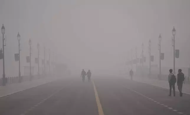 FILE - People walk through smog in New Delhi, India, Dec. 15, 2025. (AP Photo/Piyush Nagpal, File)
