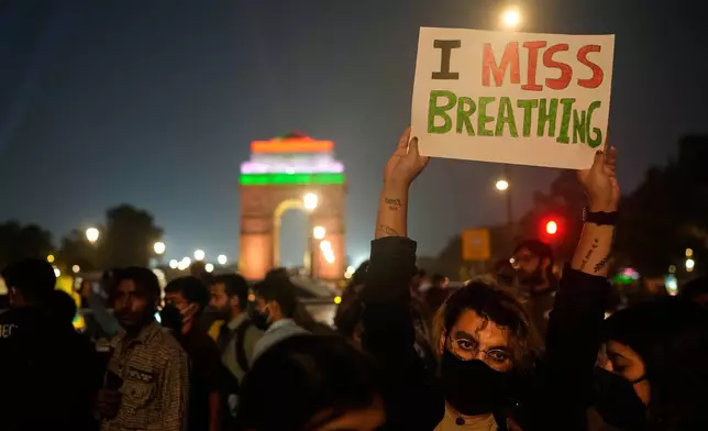 FILE - A person holds a sign during a protest against what they called the government's lack of action to combat air pollution in New Delhi, India, Nov. 9, 2025. (AP Photo/Manish Swarup, File)