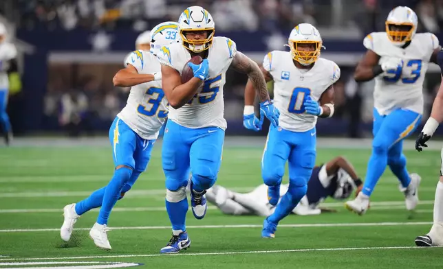 Los Angeles Chargers linebacker Tuli Tuipulotu (45) runs after recovering a fumble by Dallas Cowboys quarterback Joe Milton 10) during the second half of an NFL football game Sunday, Dec. 21, 2025, in Arlington, Texas. (AP Photo/Julio Cortez)