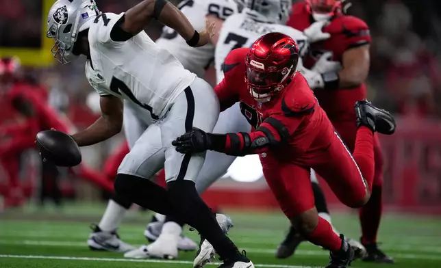 Houston Texans defensive end Derek Barnett, right, sacks Las Vegas Raiders quarterback Geno Smith (7) during the second half of an NFL football game, Sunday, Dec. 21, 2025, in Houston. (AP Photo/Eric Christian Smith)