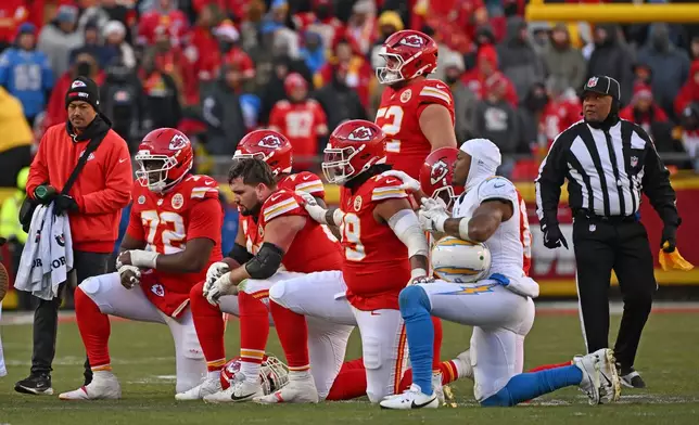 FILE - Kansas City Chiefs and Los Angeles Chargers players take a knee after Chiefs quarterback Patrick Mahomes (15) was injured during an NFL football game Sunday, Dec. 14, 2025, in Kansas City, Mo. (AP Photo/Peter Aiken, File)