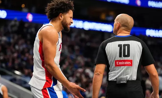 Detroit Pistons guard Cade Cunningham discusses a call with referee John Goble (10) in the first half of an NBA basketball game against the Dallas Mavericks in Dallas, Thursday, Dec. 18, 2025. (AP Photo/Tony Gutierrez)