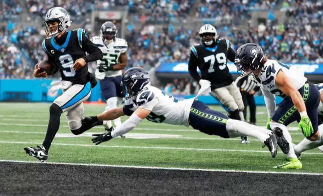 Carolina Panthers quarterback Bryce Young scores past Seattle Seahawks safety Ty Okada during the second half of an NFL football game, Sunday, Dec. 28, 2025, in Charlotte, N.C. (AP Photo/Rusty Jones)
