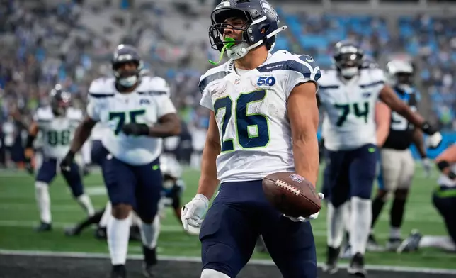 Seattle Seahawks running back Zach Charbonnet celebrates after scoring against the Carolina Panthers during the second half of an NFL football game, Sunday, Dec. 28, 2025, in Charlotte, N.C. (AP Photo/Jacob Kupferman)