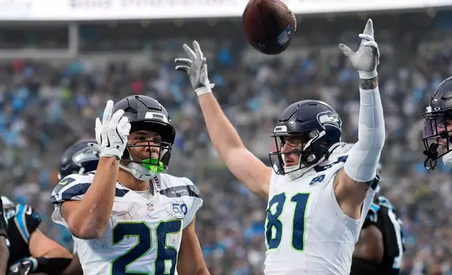 Seattle Seahawks running back Zach Charbonnet celebrates after scoring against the Carolina Panthers during the second half of an NFL football game, Sunday, Dec. 28, 2025, in Charlotte, N.C. (AP Photo/Jacob Kupferman)