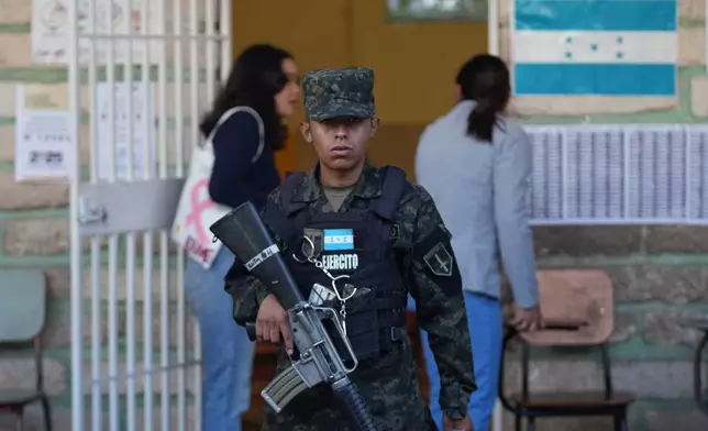 A soldier guards a polling station during general elections in Tegucigalpa, Honduras, Sunday, Nov. 30, 2025. (AP Photo/Moises Castillo)
