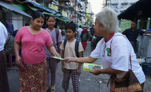 A member of the Shan and Nationalities Democratic Party (SNDP) distributes leaflets of their party during the last day of the first phase of their election campaign in Yangon, Myanmar, Friday, Dec. 26, 2025. (AP Photo/Thein Zaw)