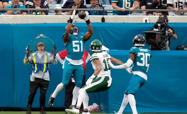 Jacksonville Jaguars linebacker Ventrell Miller (51) intercepts a pass against New York Jets wide receiver Allen Lazard (10) during the second half of an NFL football game, Sunday, Dec. 14, 2025, in Jacksonville, Fla. (AP Photo/John Raoux)