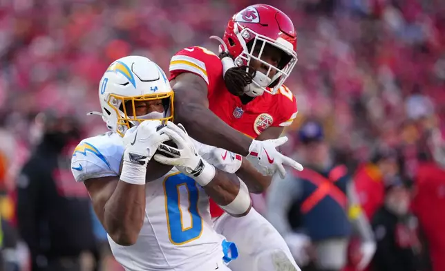 Los Angeles Chargers linebacker Daiyan Henley (0) intercepts a pass intended for Kansas City Chiefs running back Kareem Hunt during the second half of an NFL football game Sunday, Dec. 14, 2025, in Kansas City, Mo. (AP Photo/Ed Zurga)